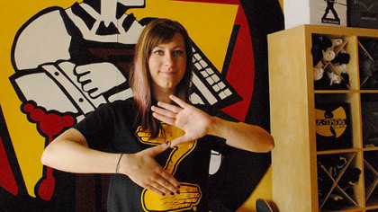 Andrea Bible, who works at South Side T-shirt store CommonWealth Press, makes the Zoltan "Z" sign with her fingers while wearing the company's Zoltan shirt that is quickly becoming popular across the city.