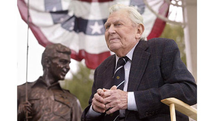 This Oct. 28, 2003 file photo shows actor Andy Griffith sitting in front of a bronze statue of Andy and Opie from the "Andy Griffith Show," after the unveiling ceremony in Raleigh, N.C.