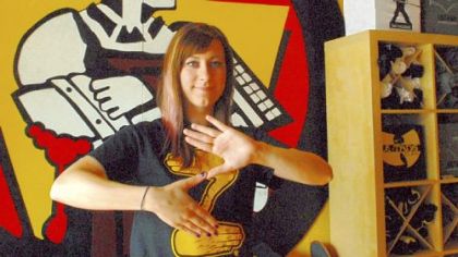 Andrea Bible, who works at the CommonWealth Press T-shirt store on the South Side, does the Zoltan sign. The store created a  Zoltan shirt that quickly is becoming popular across the city.