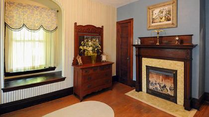 This bedroom includes large windows and one of the home's seven decorative fireplaces.