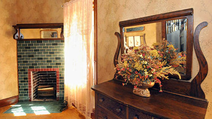 This bedroom includes one of the home's seven decorative fireplaces.