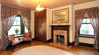 The master bedroom includes large windows and one of the home's seven decorative fireplaces.