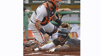 The Pirates' Josh Harrison beats a throw home in front of Giants catcher Hector Sanchez Friday night at PNC Park.