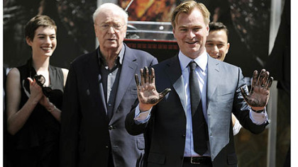 Christopher Nolan director of the film "The Dark Knight Rises," holds up his hands after putting them in cement during a ceremony for him at Grauman's Chinese Theatre.