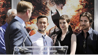 Christopher Nolan director of the upcoming film "The Dark Knight Rises," looks over at cast members, Morgan Freeman, Joseph Gordon-Levitt, Anne Hathaway and Christian Bale during his hand-and-footprint ceremony at Grauman's Chinese Theatre.