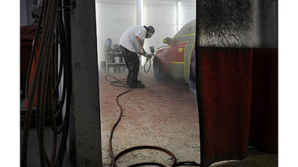 William Lieberth Sr. says he wants to leave the shop to his son, Bill Lieberth, 34, pictured above painting a Hyundai Elantra on Monday.