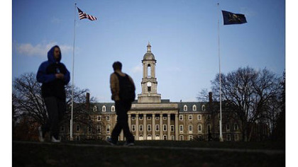 Students walk in front of the Old Main building on the Penn State campus in State College, Pa.