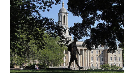 A Penn State University student walks in front of Old Main on campus today.