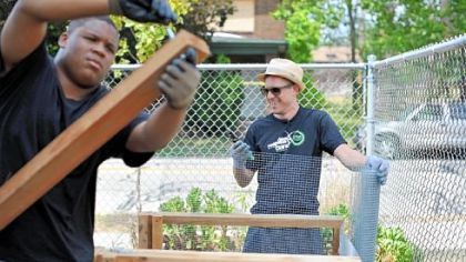 Stefan Lessard, the bassist for the Dave Matthews Band, right, works alongside Jaymier Scarbrough, 15, of Wilkinsburg at the Homewood-Brushton YMCA's community garden.