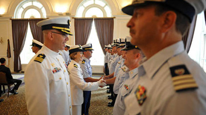 Incoming Commander Lindsay Weaver, center, shakes hands with members of her unit.