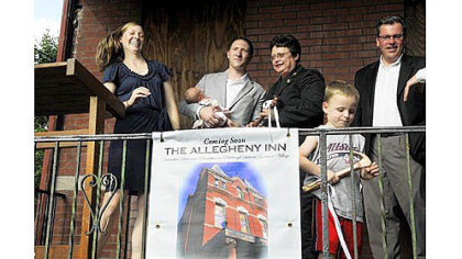 Keili and Justin Mistovich, left, holding daughter Madeline, 3 months, next to Darlene Harris, City Council president, Mark Masterson of the North Side Community Development Fund and Mayor Luke Ravenstahl's son Cooper, 31/2, with a ceremonial hammer, at the announcement of the purchase of a building at East Ohio and Cedar Avenue for a bed and breakfast.