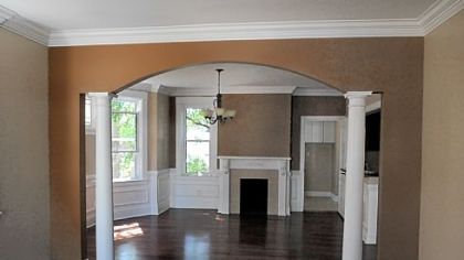 The dining room was changed dramatically after a wall dividing the living room was removed. An arch was created between the two rooms that is bookended by a pair of white pillars.