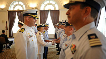 Incoming Commander Lindsay Weaver, center, shakes hands with members of her unit.