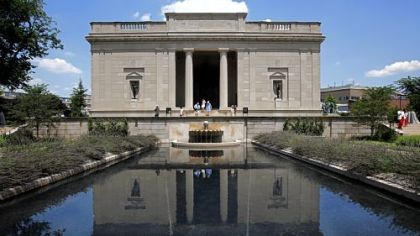 Visitors walk out toward the formal French garden, fountain and reflecting pool of the Rodin Museum in Philadelphia.