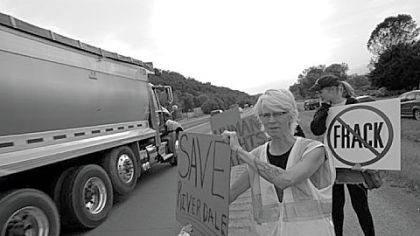 Activist Wendy Lynne Lee takes the protest to Route 220 in front of the Riverdale Park, where much of the passing truck traffic is related to natural gas well development.