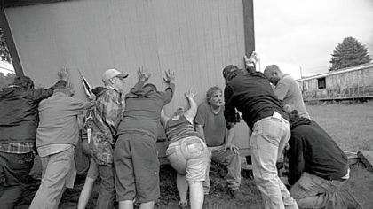 Eric Daniels, his wife, April, and remaining neighbors and activists place his shed on a truck that will take it to their new home. Mr. Daniels is also a truck driver who hauls water for the natural gas industry.