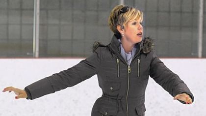 Clad in a parka, Beth Sutton shows how to go into a spin for her student at the Robert Morris University's Island Sports Center on Neville Island.