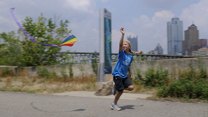 Olivia Sobkowiak, 10, a Girls on the Run representative, flies a kite before a news conference today calling on the Environmental Protection Agency to adopt stronger standards for fine particulate matter. "Most kids don't know about [the problems with] air quality," she said.