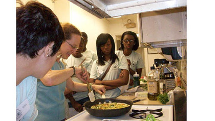Slow Food Pittsburgh's Justine Cassell cooks in the Phipps Garden Center Kitchen with, left to right, interns Lauryn Robinson, Denise Porter and Kiehl Jackson watching.