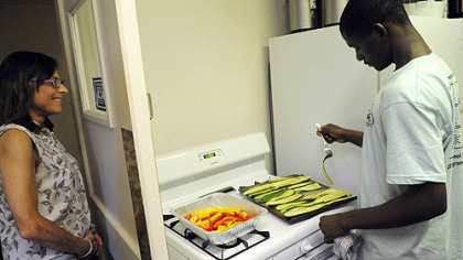 Mberwa Mada, 17, cooks zucchini while program coordinator Kate Borger looks on at Phipps Garden Center. Eight high school interns had their first cooking session June 21.