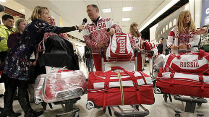 Russian Olympic sailing team coach Sergay Kuzovov, center, is interviewed by the media as he arrives with other team members at Heathrow Airport Monday, July 16, 2012, as competitors pour into London during preparations for the upcoming London 2012 Olympic Games.