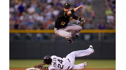 Pirates shortstop Clint Barmes  jumps over a sliding Dexter Fowler after turning a double play in the third inning Tuesday night at Coors Field in Denver.