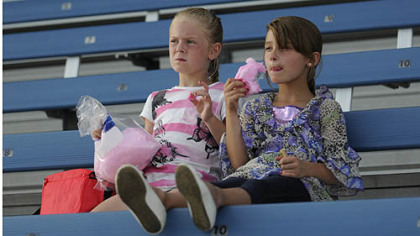Twins Katie and Karlie Leadingham, 6, of Canonsburg eat cotton candy Saturday as they wait for the start of the Washington Wild Things game against the Traverse City Beach Bums.