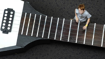 Nolan Casey, 8, of Harrison City jams on the Gibson Flying V guitar on display at the Carnegie Science Center on Tuesday.