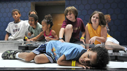 Davion Huckaby of Morgantown, W.Va., rests for a bit on the body of the world's largest playable guitar, on display at the Carnegie Science Center. Davion was there with his brothers, sisters and friends.