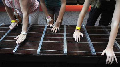 From left, Karen Landis, of McCandless, and her daughters Josie, 14, and Claire, 12, play the world's largest playable guitar together.