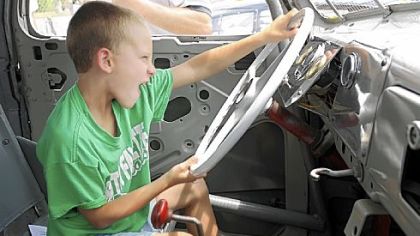 Shane Palmer, 6, of Brentwood, tries out an old race car Sunday before a dedication ceremony for the former Heidelberg Raceway and Sports Arena. The raceway played an important role in early NASCAR racing history.