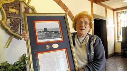 Natalie Carbone Mangini, who is manager of Carbone's Restaurant in Crabtree, also happens to have been a nuclear chemist for Westinghouse who worked on the atomic submarine Nautilus. She holds a picture of the sub and list of accomplistments presented to her.