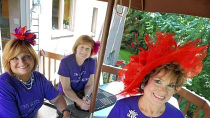 Members of a local chapter of the Red Hat Society, called the Glitz and Glamour Girls, are, from left, Donna Rotoloni, Mary Ann McCloskey and a local Red Hat "Queen," Cathie Shenefelt, at Ms. Shenefelt's home in McMurray.