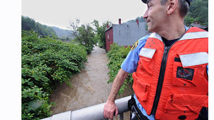 Pittsburgh paramedic Don Cunningham checks out the water level of the Streets Run Creek from Ramp Street in Hays.