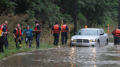 Pittsburgh firefighters lead a stranded passenger to safety after her vehicle  was stuck in rising water on Route 51 near Bausman Street.