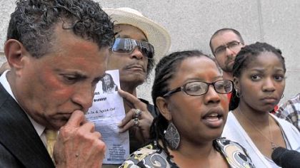 Kielan Miles, 18, right, the sister of Jordan Miles, and Tim Stevens, left, head of the Black Political Empowerment Project, listen outside the federal courthouse Thursday to Brandi Fisher, center, talk about Mr. Miles' testimony against the police officers who he said beat him.