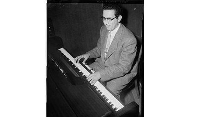 George "Duke" Spaulding smiles slightly while playing the piano in the Hill District, circa 1950-1960.