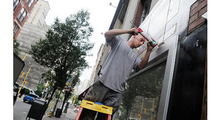 Dave Nemes, from Nemes Glass Corp., caulks windows Thursday next to the Penn Garrison. Construction and renovation projects are springing up all across the 800 and 900 blocks of Penn Avenue, Downtown.