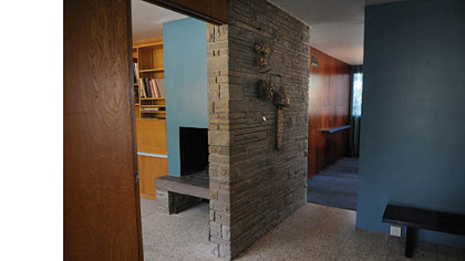 The front entry way has a polished terrazzo floor.  To the left is a den with a log-burning fireplace.