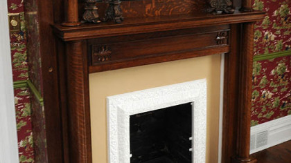 The decorative wooden mantlepiece and fireplace surround is highlighted with a mirror.
