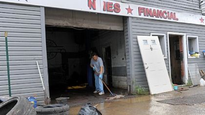 Rick Ibrahim sweeps out water from Best Auto Mart along Route 51 in the South Hills on Saturday after strong storms caused flash flooding Friday evening.