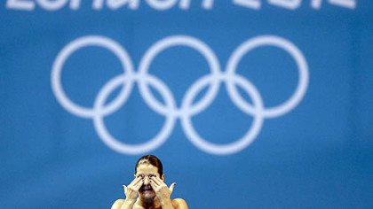 Brazilian diver Juliana Veloso wipes water from her eyes while training at the 2012 London Olympics, Sunday, July 22, 2012, in London.