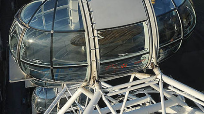 Amelia Hempleman-Adams poses with the Olympic Flame on top of a London Eye pod with a view of the metropolis from the super-Ferris wheel attraction on the Torch Relay leg through London, Sunday July 22, 2012.