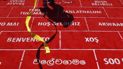 A performer walks on the carpet during the Olympic Team Welcome Ceremony at the Athletes' Village at the Olympic Park, Sunday, July 22, 2012, in London.