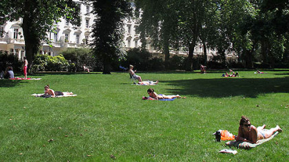 Sunbathers soak up rays in a southwest London park on Sunday, July 22, 2012. After weeks of unseasonably chilly temperatures, the sun has come out in the capital with less than a week to go until the start of the London Olympics.