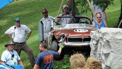 Crews remove Philip Cooper's 1974 MGB after it crashed into a stone monument along East Circuit Drive during the MG Marque Race, part of the 30th annual Vintage Grand Prix in Schenley Park. Mr. Cooper was not injured.