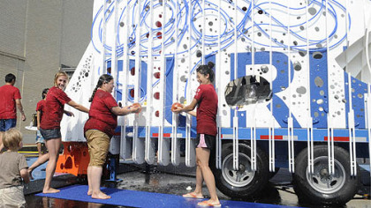 CMU architecture students and designers of the Puriflume, from left, Sara Gotschewski, Michelle Spitzer, and Inkyoung Kim, play on Thursday. The Puriflume, a playplace with a water slide and funky spray nozzles, is an eco-friendly feature that filters and recirculates water.