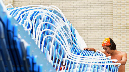 Ming Ming Lin, a Carnegie Mellon University alumna, sets up the Puriflume at the school on Wednesday. CMU unveiled the water playplace, nicknamed the EcoBeastie, on Thursday as a play session with a water slide and funky spray nozzles.