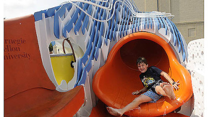 Seven-year-old Dylan Folan slides down the Puriflume, a 14-foot play contraption that filters and recirculates water, on Thursday. Students taught by Dylan's father, Carnegie Mellon University architecture professor John Folan, designed the feature with community input. The city will be looking at it for possible replication in future spray parks.