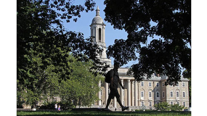 A Penn State University student walks in front of Old Main on campus. The school will learn its punishment from the NCAA today.